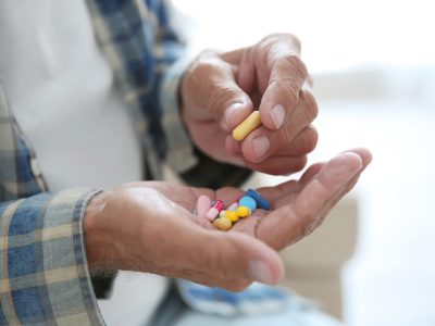 Senior man taking pills, closeup