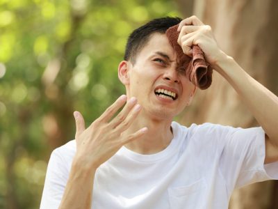 タオルで汗を拭う男性